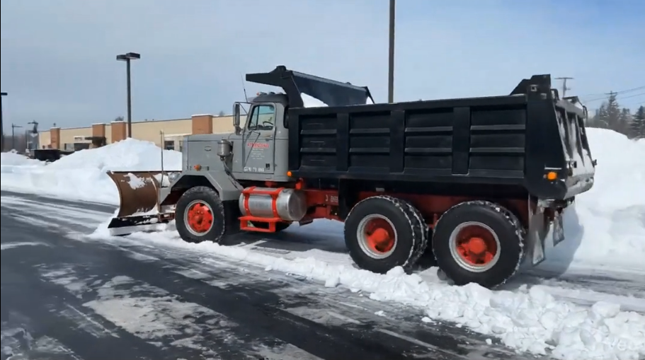 Commercial snow plow clearing a parking lot